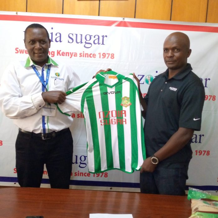 Nzoia Sugar Football Club Chairman Mr. Evans Kadenge (L) hands over the Clubs Jersey to Salim Babu (R) the newly appointed Head Coach